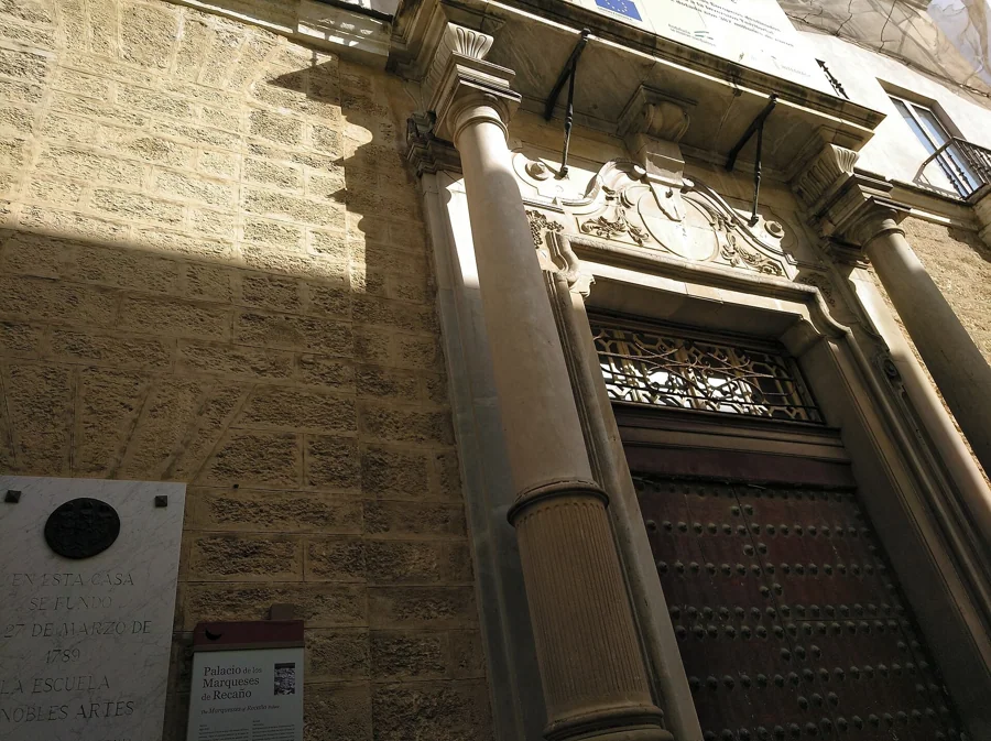 Portada de mármol de la Casa Recaño con la Torre Tavira de Cádiz al fondo