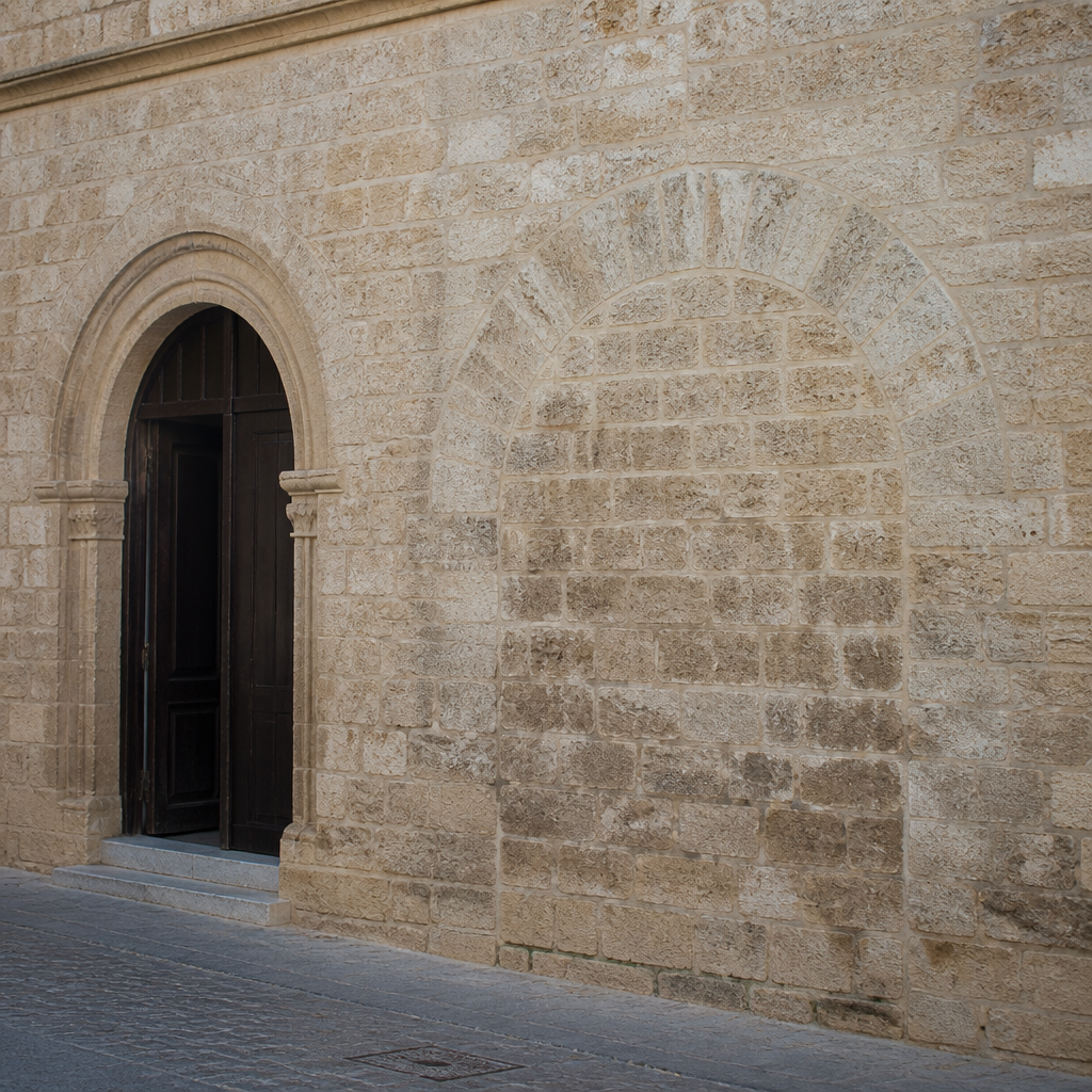 Puerta lateral de la Asunción junto al arco cegado de la antigua Puerta de las Gradas.